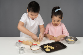 Menina e seu irmão fazendo biscoitos