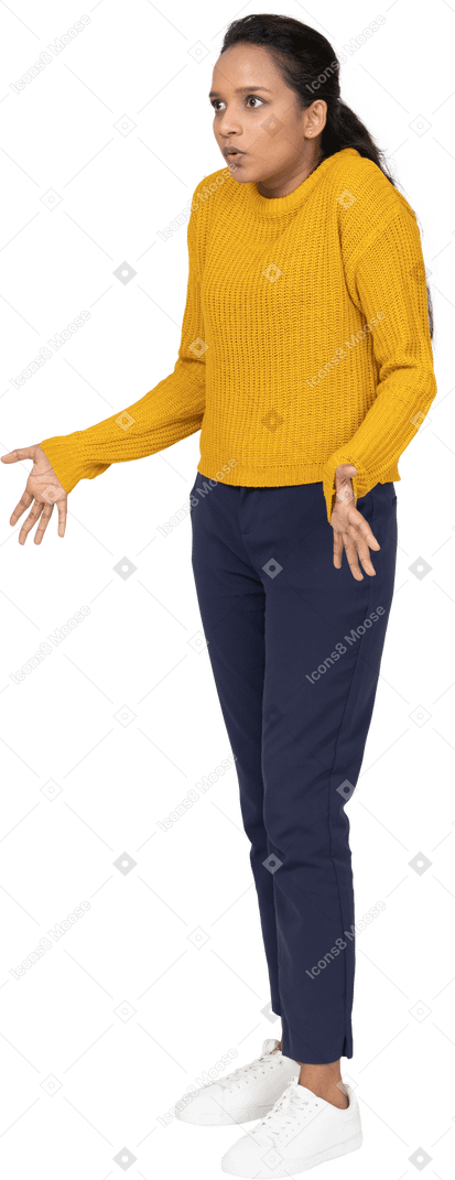 Front view of a confused girl in casual clothes standing with outstretched arms