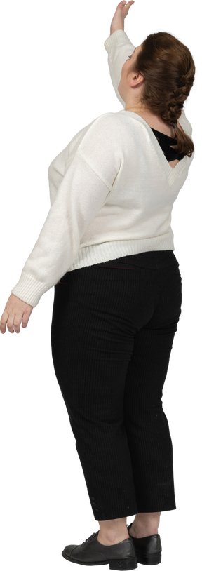 Rear view of a plus size woman in casual clothes with raised arm