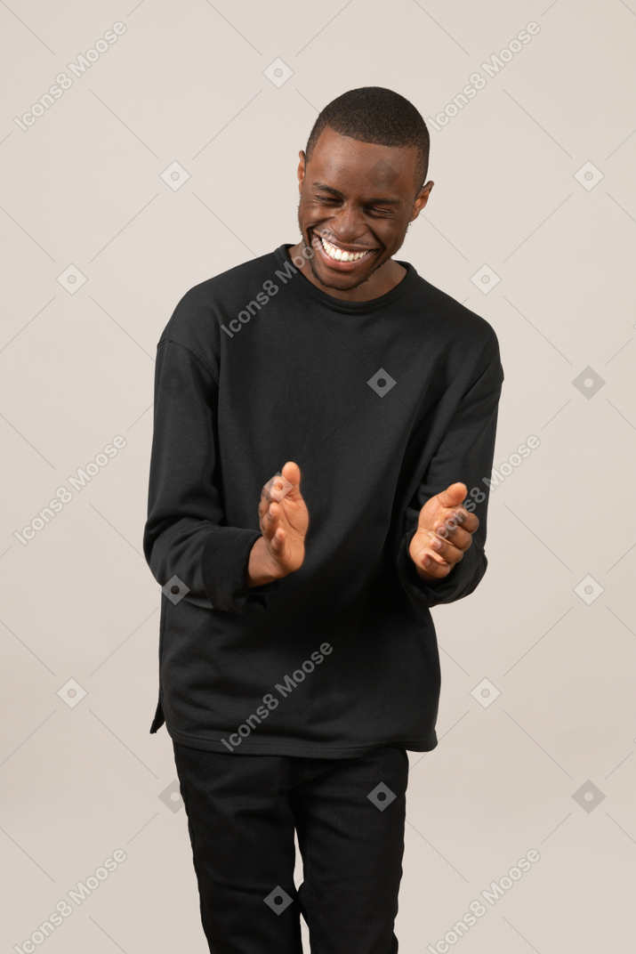 Young man clapping hands and laughing