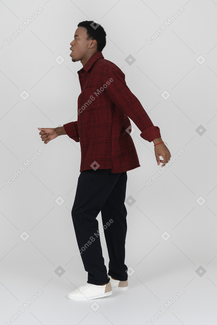Black man in casual clothes walking