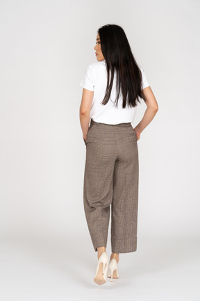 Back view of a walking young lady in breeches and t-shirt