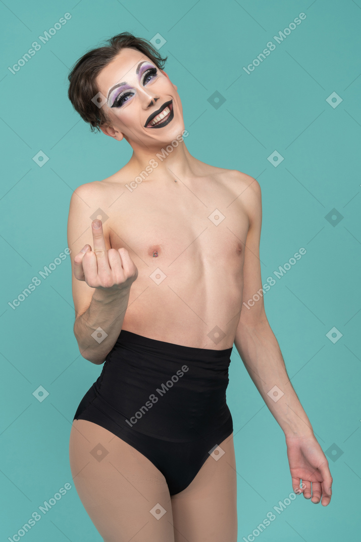 Трансвестит улыбается и показывает средний палец
