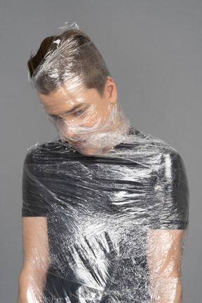 Close up of a young man wrapped in plastic