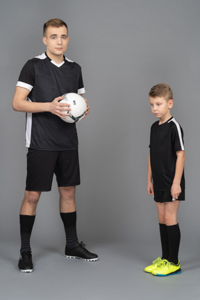 Full-length of a young man coaching little boy