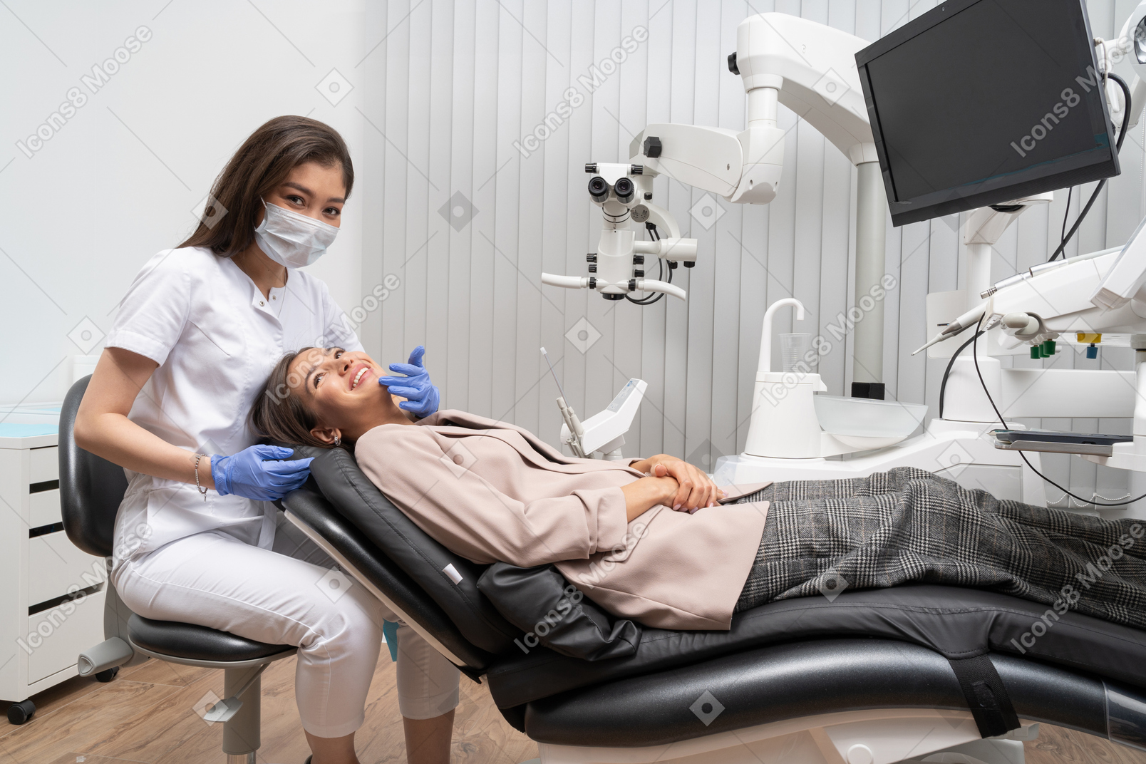 Full-length a pleased female dentist and her smiling female patient