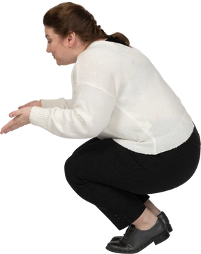Side view of a plump woman in casual clothes squatting