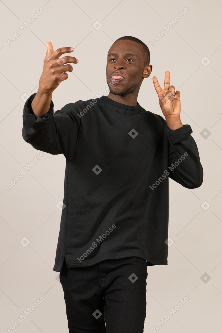 Black man taking selfie with imaginary smartphone