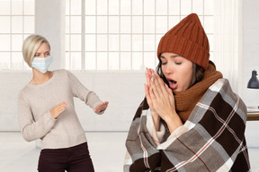 Woman backing away from sick woman