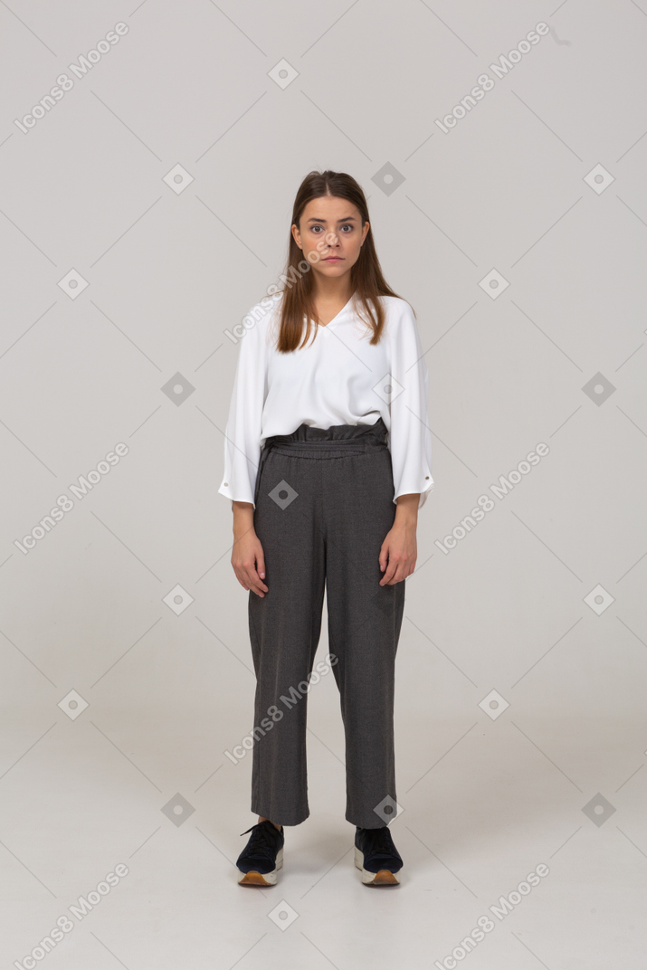 Front view of a surprised young lady in office clothing looking at camera