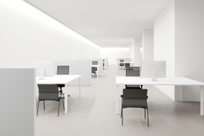Workplace with white walls, desks and office chairs