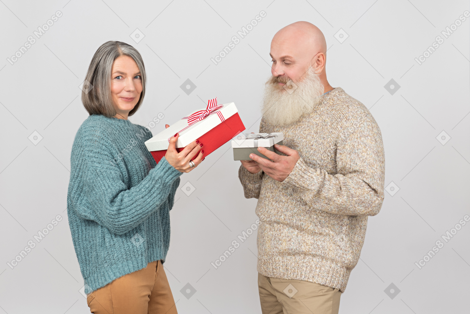 Elegant elderly couple giving gifts to each other