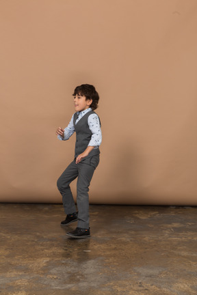 一个穿着西装跳舞的男孩的侧视图