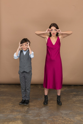 Front view of stylish boy and woman widening their eyes