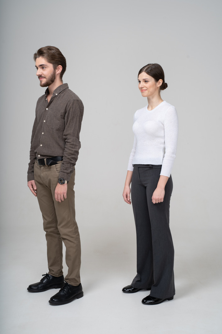 Three-quarter view of a pleased young couple in office clothing