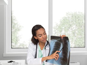 A female doctor looking at a x - ray image