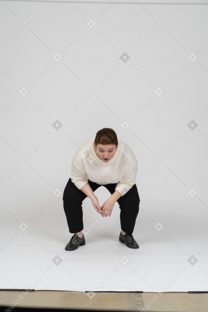 一个穿着休闲服蹲着的胖女人的正面图