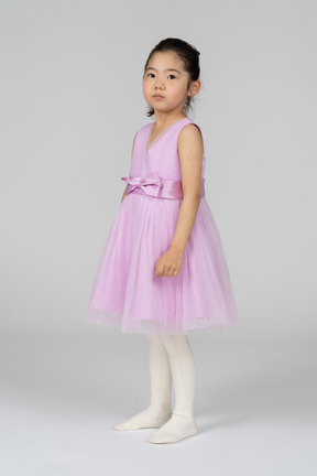 Cute little girl in pink dress looking at camera