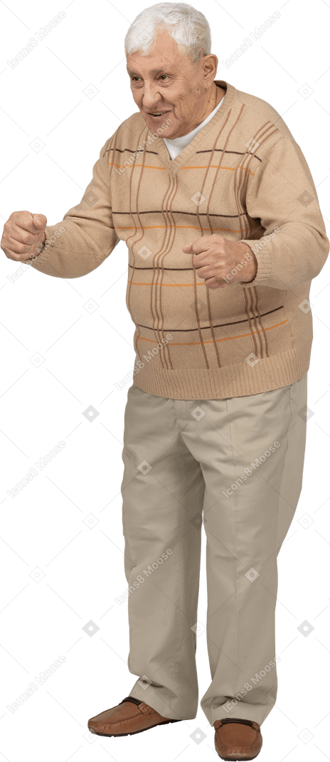 Vue de face d'un vieil homme heureux dans des vêtements décontractés debout avec les poings serrés