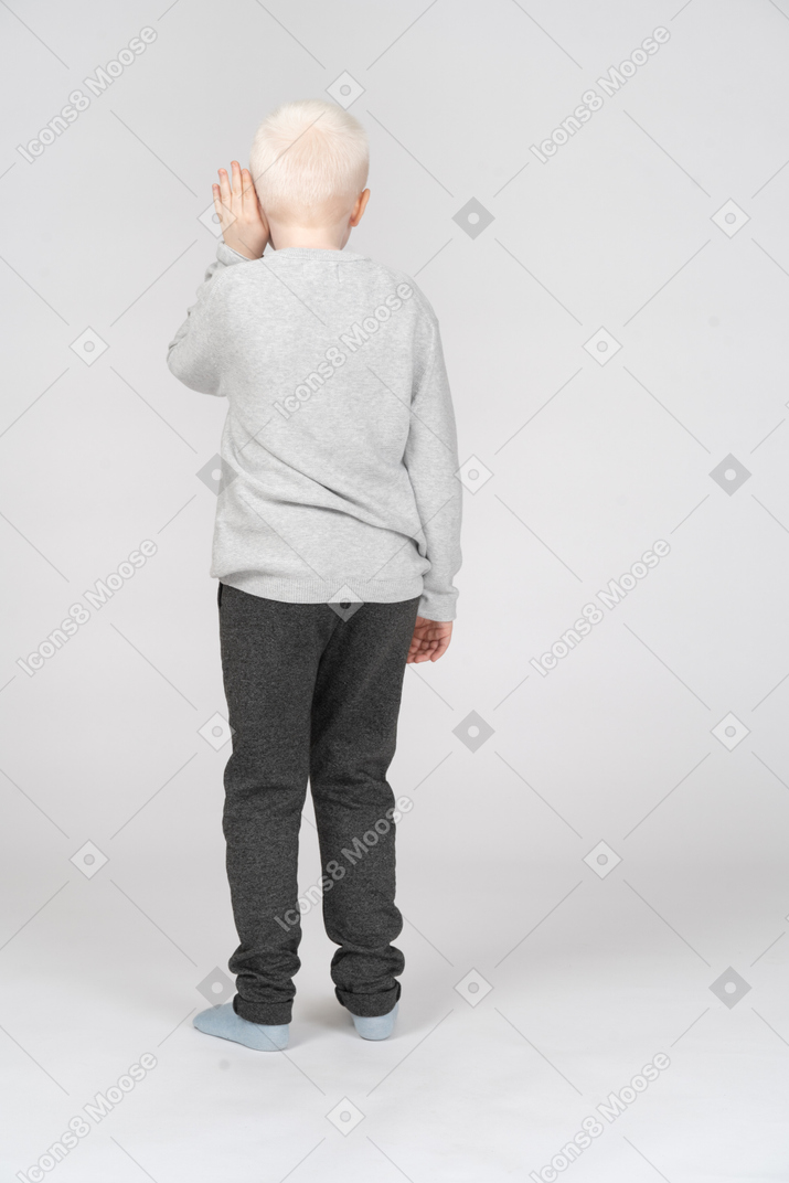 Vista traseira de um menino escutando