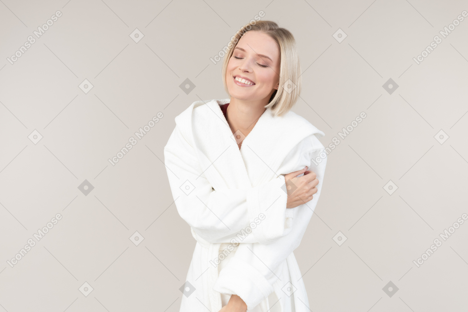 Smiling young woman in bathrobe standing halfsideways