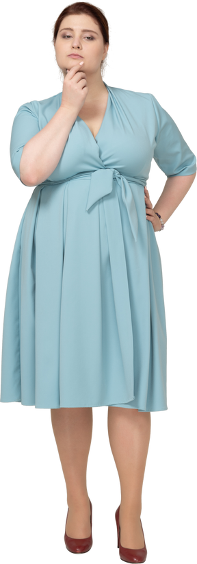 Vista frontal de uma mulher de vestido azul pensando