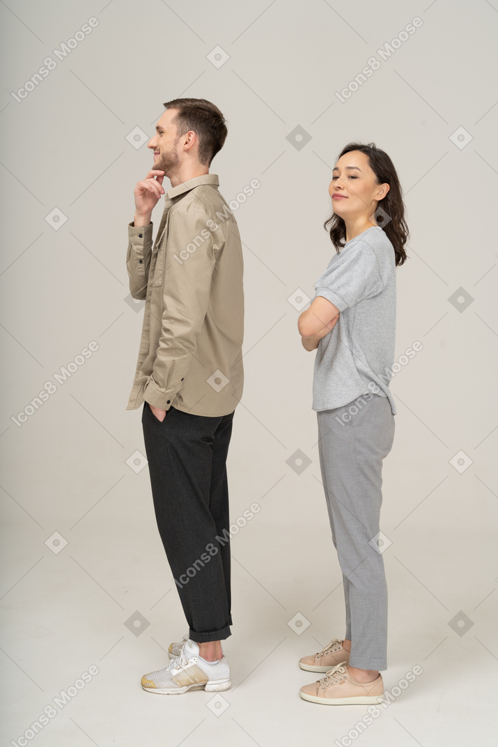 Side view of young couple standing with hand on chin