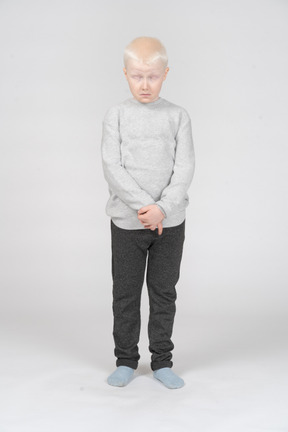Front view of a sad ashamed kid boy with his eyes closed