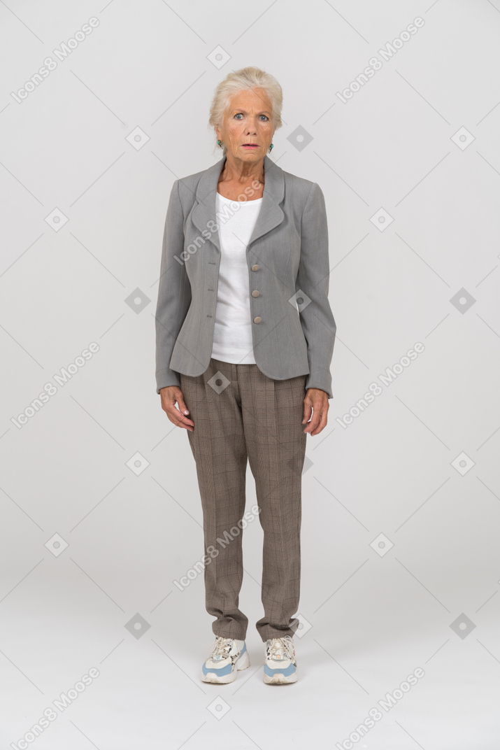 Vista frontal de una anciana en traje mirando a la cámara
