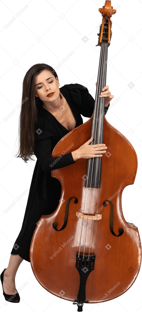 一个年轻的女人，穿着黑色的连衣裙，演奏低音提琴和往下看的前视图