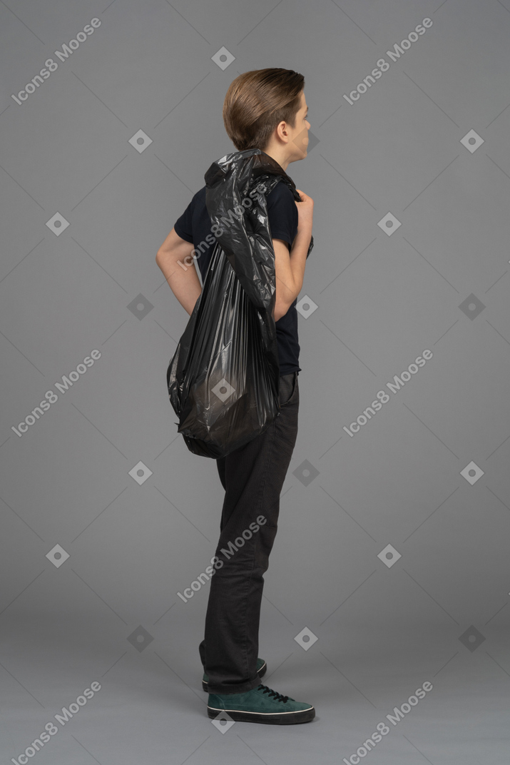 A man holding a trash bag behind his back