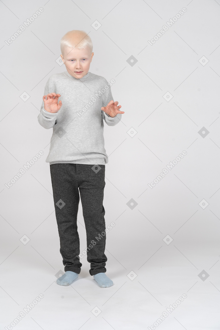 Niño pequeño de pie con las manos extendidas