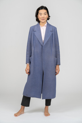 Smiling woman with closed eyes wearing blue coat