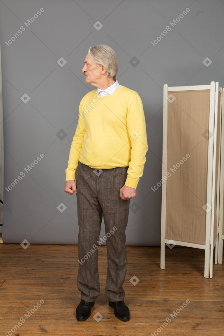 Front view of an old man clenching fists while turning around