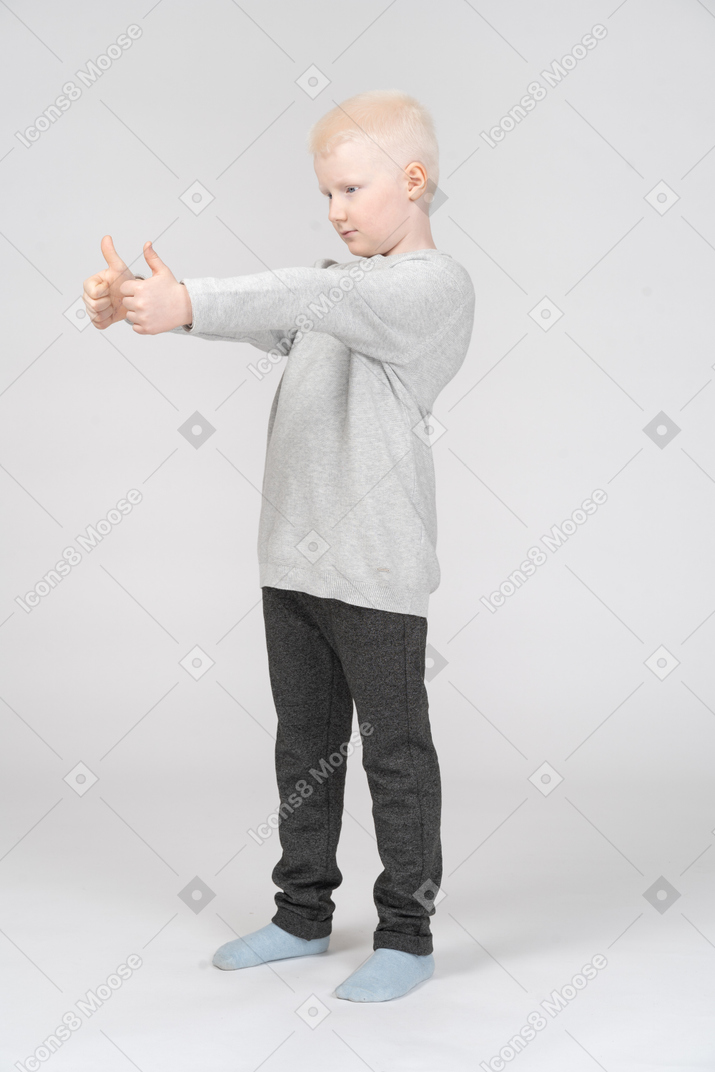 Little boy showing two thumbs up