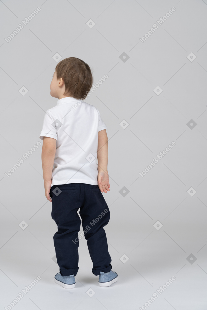 A boy standing in front of a wall