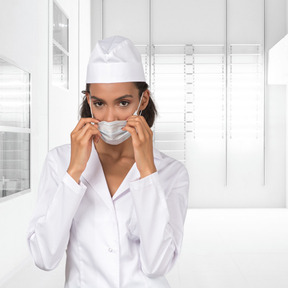 A female nurse adjusting her face mask