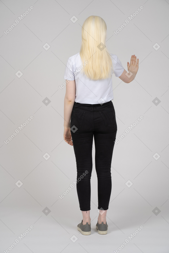 Back view of a young girl showing stop hand signal