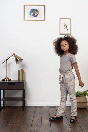 Good looking girl kid posing on the apartment background