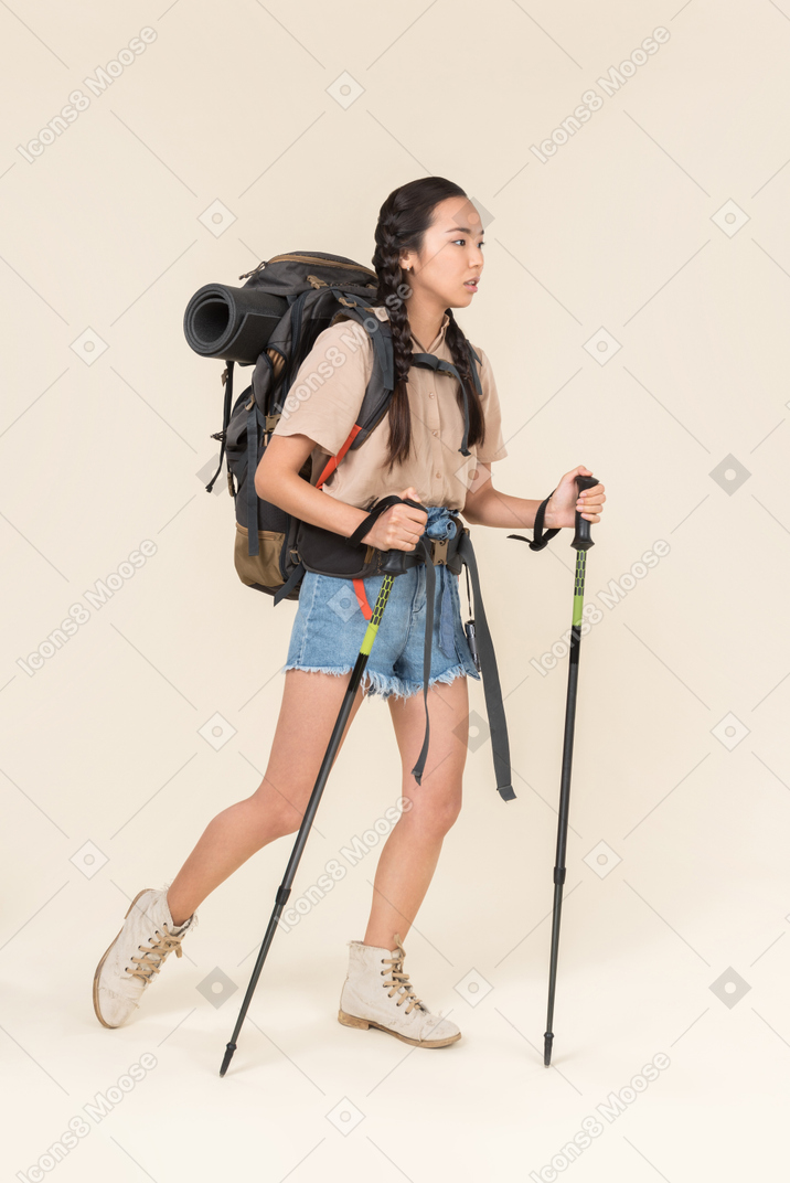 Hiker woman walking using trekking poles