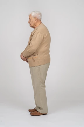 Old man in casual clothes standing in profile