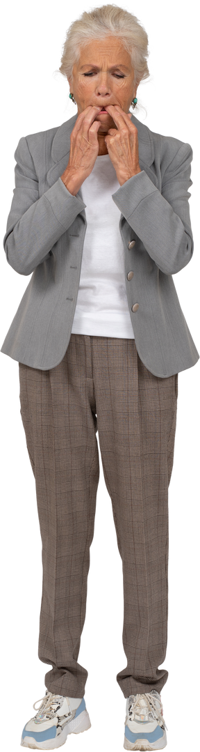 Vista frontal de una anciana en traje silbando con los dedos