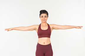 Indian woman in sportswear standing with hands spread