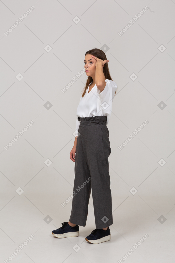 Three-quarter view of a young lady in office clothing looking aside & touching head