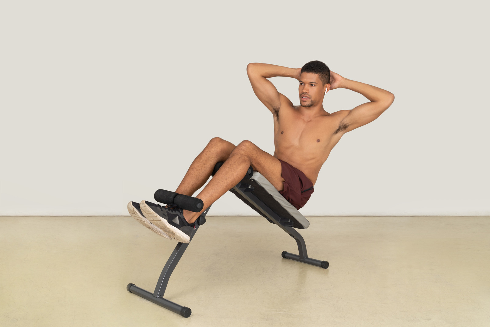 A three-quarter side view of the young muscular man doing exercises and looking forward