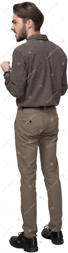 Three-quarter back view of a furious man in office clothing clenching fists