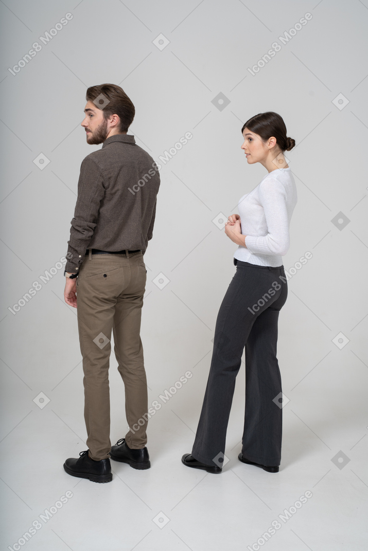 Three-quarter back view of a young couple in office clothing