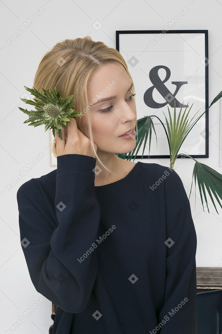 A woman with a plant in her hair