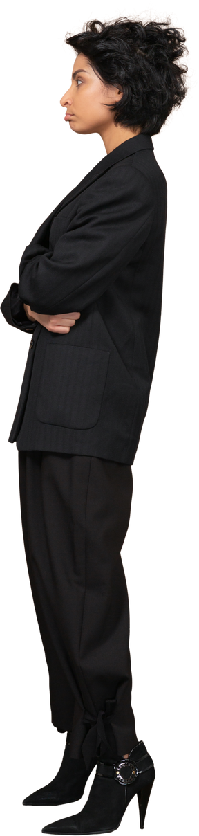 Vista lateral de una empresaria haciendo pucheros vestida con traje negro