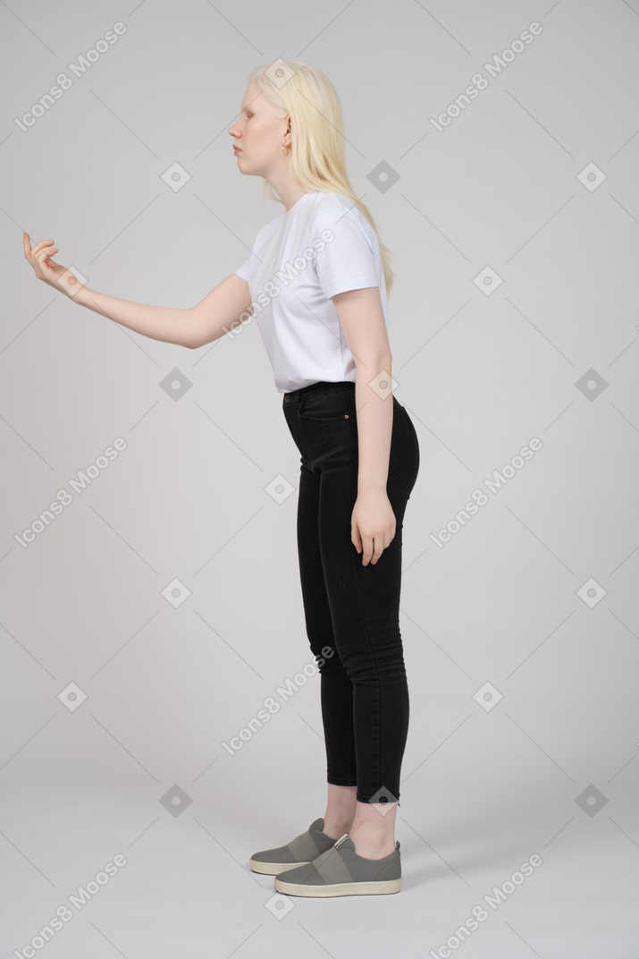 Vista de perfil de uma jovem de pé com sinal de mão acenando